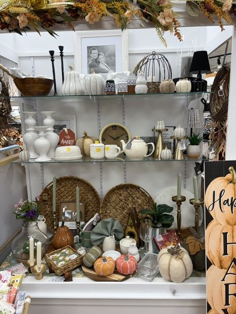 Fall décor shelves with pumpkins, candlesticks, and serving pieces at Trendys